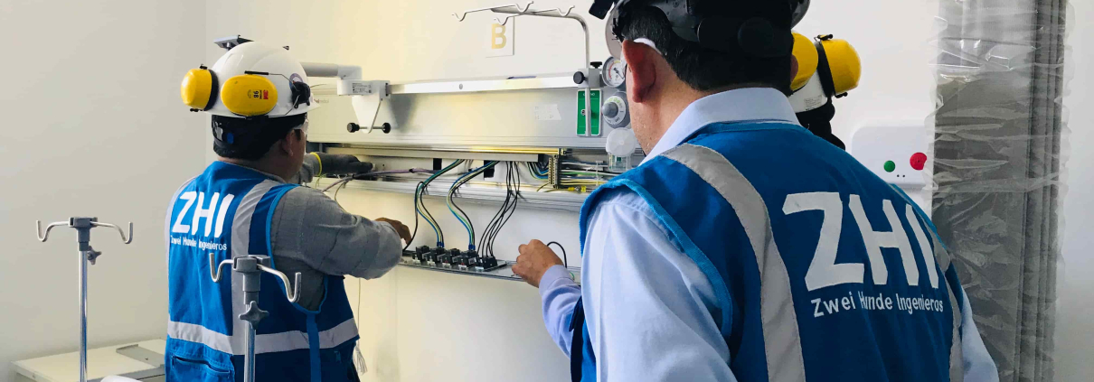 Ingenieros de ZHI instalando panel de cabecera de cama hospitalaria con tomas de gases medicinales